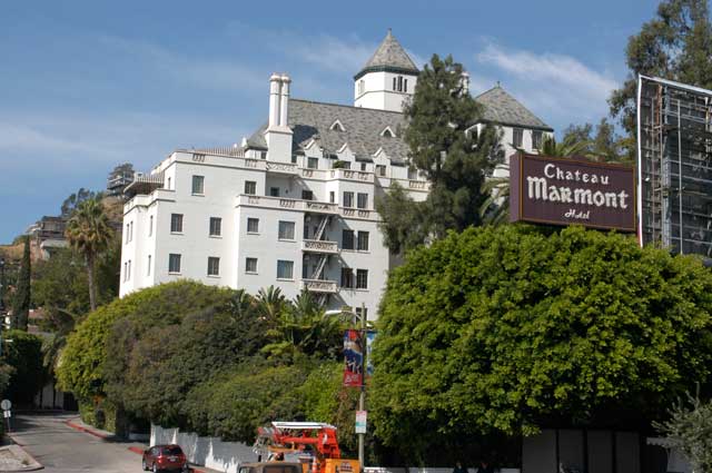 Excerpt from The Drop
(Photo by Wendy Werris)
The Chateau Marmont sat above the Sunset Strip like an old world castle with a neon sign out front. An iconic structure set against the Hollywood Hills, it had enticed movie stars, writers, rock and rollers, and their entourages for decades. Several times during his career Bosch had been to the hotel as he had followed cases and sought witnesses and suspects. He knew its beamed lobby and hedged courtyard and the layout of its spacious suites. Other hotels offered amazing levels of comfort and personal service. The Chateau offered old world charm and a disinterest in your personal business. Most hotels had security cameras, hidden or not, in all public spaces. The Chateau had few. The one thing the Chateau offered that no other hotel on the strip could touch was this level of privacy. Behind its walls and tall hedges was a world without intrusion, where those who didn’t want to be watched were not. That is, until things went wrong, or private behavior became public. Chateau Marmont