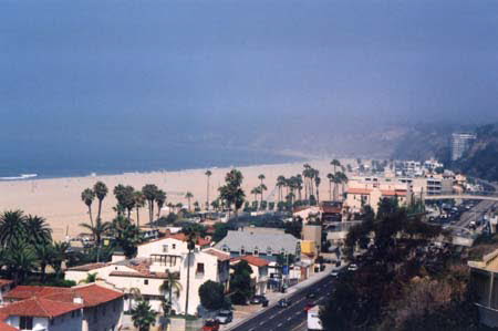 Excerpt From Chasing The Dime (Photo by Wendy Werris)
He went out onto the balcony and stared out at the cold blue ocean. He was twelve floors up. The view stretched from Venice on the south side to the ridge of the mountains sliding into the sea off Malibu to the north. The sun was gone but there were violent slashes of orange and purple still in the sky. This high the sea breeze was cold and bracing. He put his hands in the pockets of his pants. The fingers of his left hand closed around a coin and he brought it out. A dime. Another reminder of what his life had become. Santa Monica Beach View