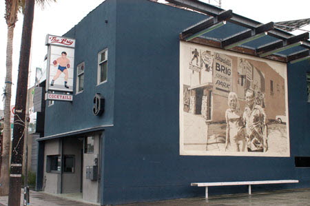 Excerpt from The Reversal (photo credit: Wendy Werris)
The lighted sign outside of The Brig depicted a boxer in a ring, his red gloves up and ready. It was an image that seemed at odds with the name of the bar, but Bosch knew the story behind it. As a much younger man he had lived in the neighborhood. He knew the sign with the boxer was put up by a former owner who had bought out the original owners. The new man was a retired fighter and had decorated the interior with a boxing motif. He also put the sign up out front. There was a still a mural on the side of the building that depicted the fighter and his wife, but they were long gone now. The Brig