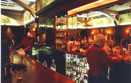 Excerpt From City Of Bones (Photo by Wendy Werris)
Musso & Frank's was an institution that had been serving martinis to the denizens of Hollywood — both famous and infamous — for a century. The front room was all red leather booths and quiet conversation with ancient waiters in red half-coats moving slowly about. The back room contained the long bar, where most nights it was standing room only while patrons vied for the attention of bartenders who could have been the fathers of the waiters. As Bosch and Brasher came into the bar two patrons slipped off their stools to leave. Bosch and Brasher quickly moved in, beating two black-clad studio types to the choice spots. A bartender who recognized Bosch came over and they both ordered vodka martinis, slightly dirty. The Bar at Musso & Franks
